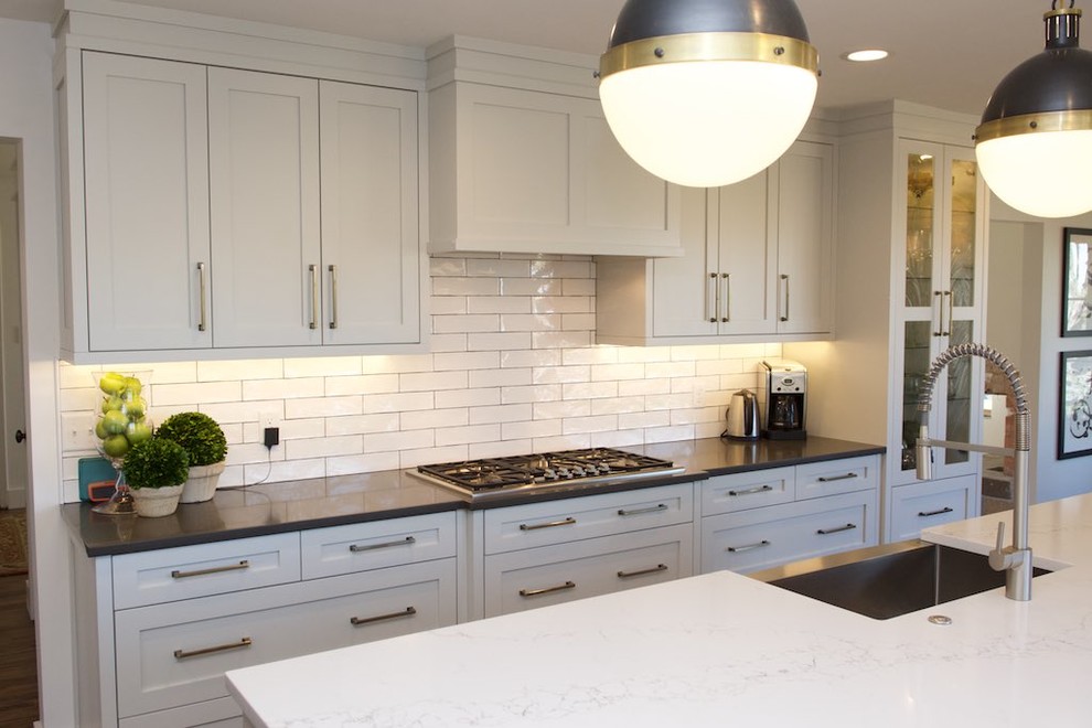 Exempel på ett mellanstort lantligt kök, med en rustik diskho, skåp i shakerstil, vita skåp, marmorbänkskiva, vitt stänkskydd, stänkskydd i porslinskakel, rostfria vitvaror, en köksö, mörkt trägolv och brunt golv