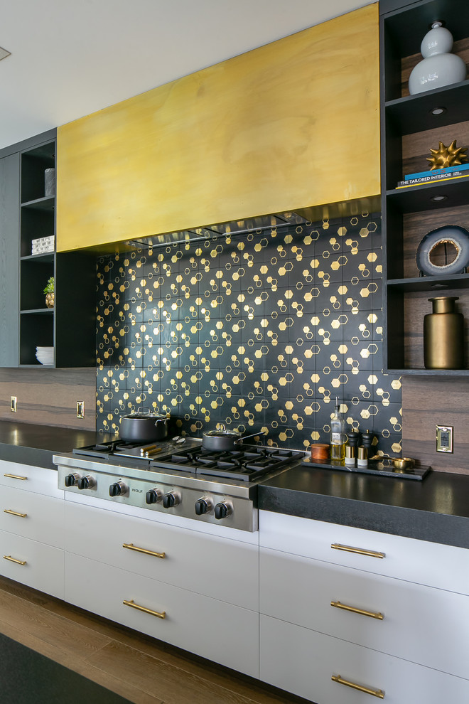 Inspiration for a large contemporary medium tone wood floor and brown floor kitchen remodel in Orange County with flat-panel cabinets, black cabinets, black backsplash, an island and black countertops
