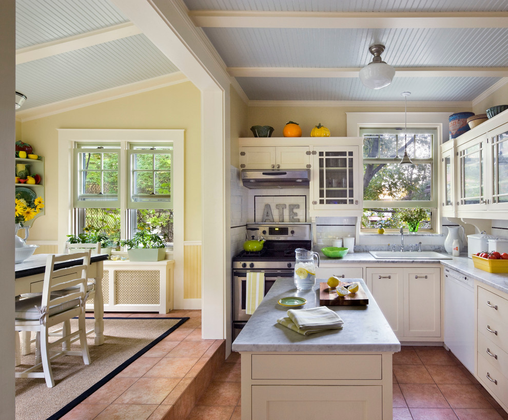 Example of a classic l-shaped eat-in kitchen design in New York with a drop-in sink, shaker cabinets, white cabinets, white backsplash, subway tile backsplash, stainless steel appliances and an island