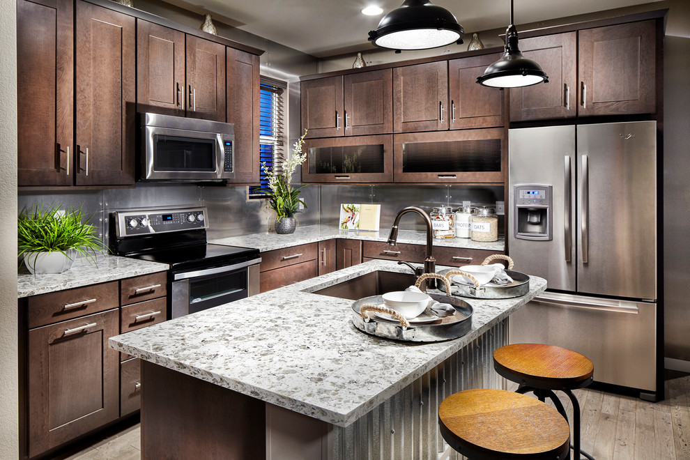 Inspiration for a mid-sized industrial l-shaped light wood floor eat-in kitchen remodel in Denver with a drop-in sink, flat-panel cabinets, medium tone wood cabinets, granite countertops, metallic backsplash, metal backsplash, stainless steel appliances and an island
