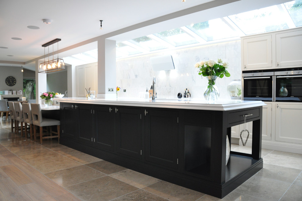 This is an example of a large classic open plan kitchen in Cheshire with a built-in sink, shaker cabinets, grey cabinets, engineered stone countertops, grey splashback, ceramic splashback, stainless steel appliances, ceramic flooring and an island.