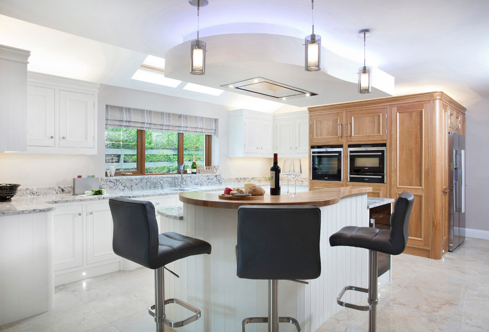 Exempel på ett avskilt, mellanstort modernt u-kök, med en undermonterad diskho, luckor med profilerade fronter, skåp i mellenmörkt trä, granitbänkskiva, beige stänkskydd, stänkskydd i sten, svarta vitvaror, marmorgolv och en köksö