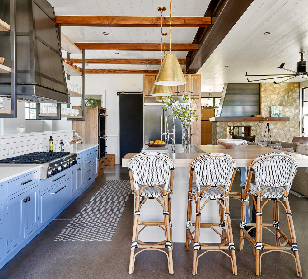 Large country l-shaped concrete floor, gray floor and shiplap ceiling open concept kitchen photo in Denver with shaker cabinets, blue cabinets, quartz countertops, white backsplash, subway tile backsplash, stainless steel appliances, an island, white countertops and a farmhouse sink