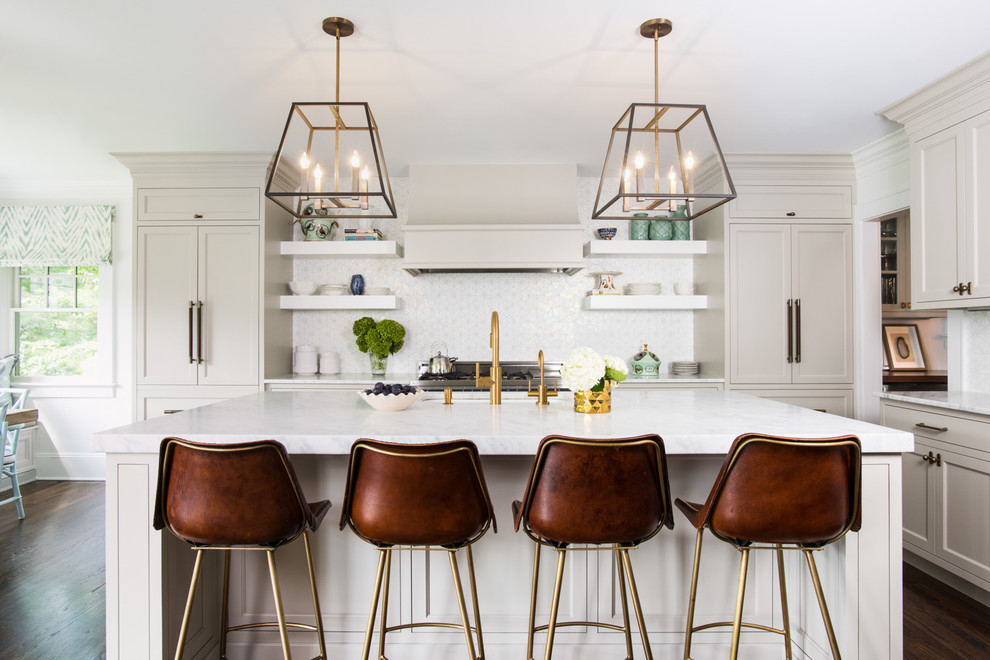 Inspiration for a transitional dark wood floor kitchen remodel in New York with shaker cabinets, beige cabinets, white backsplash, stainless steel appliances and an island