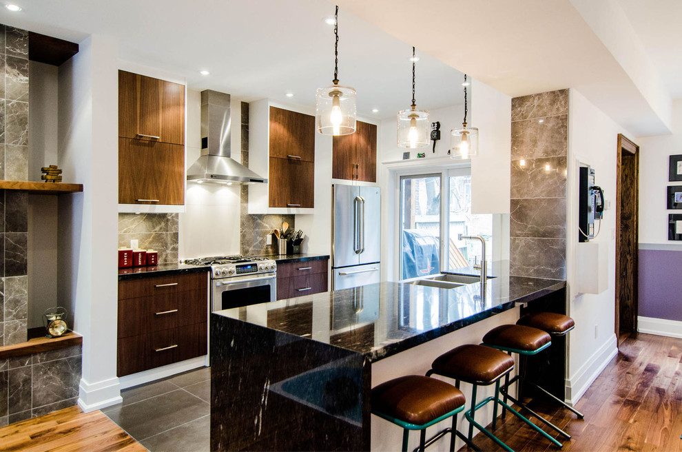 Inspiration for a contemporary galley kitchen in Toronto with a double-bowl sink, flat-panel cabinets, medium wood cabinets and stainless steel appliances.