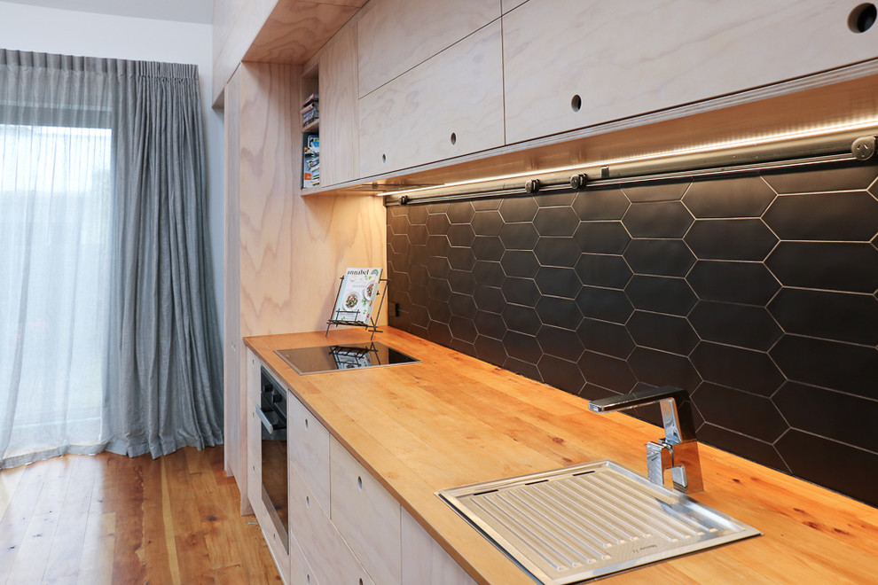 Einzeilige, Kleine Moderne Wohnküche mit Waschbecken, hellen Holzschränken, Arbeitsplatte aus Holz, Küchenrückwand in Schwarz, Rückwand aus Keramikfliesen, Küchengeräten aus Edelstahl, braunem Holzboden und Kücheninsel in Christchurch