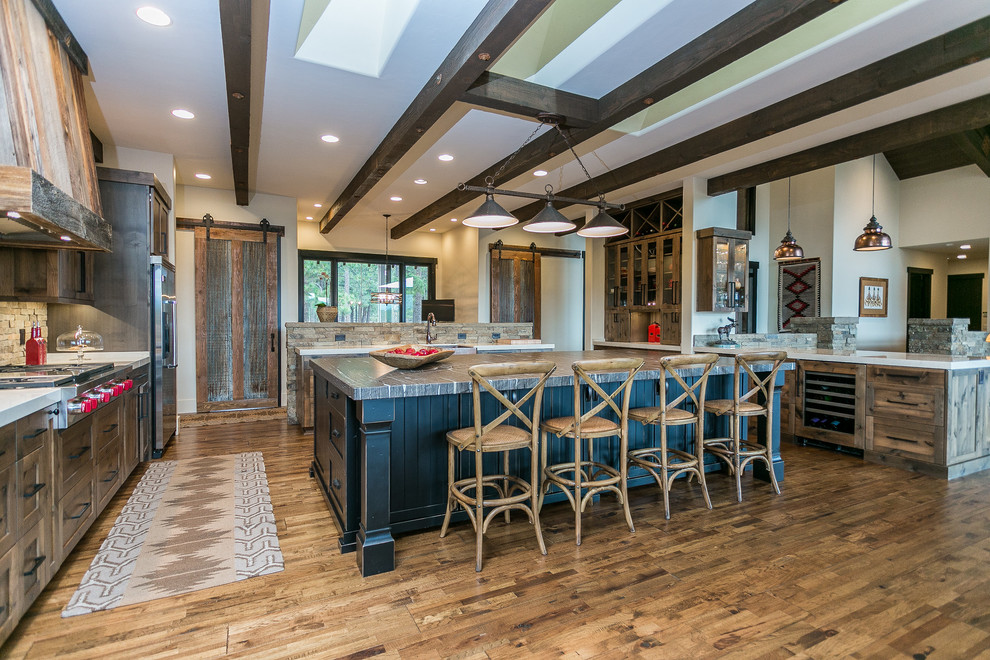 Bild på ett mycket stort rustikt linjärt kök och matrum, med luckor med infälld panel, skåp i mörkt trä, bänkskiva i kvarts, rostfria vitvaror, mörkt trägolv, en köksö och brunt golv
