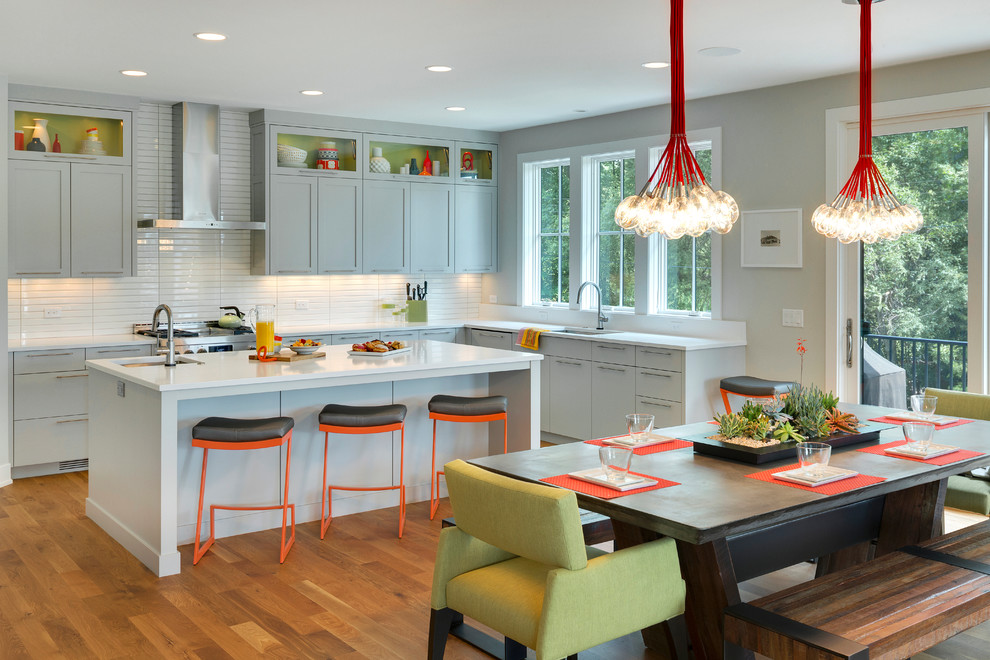 Eat-in kitchen - contemporary medium tone wood floor eat-in kitchen idea in Minneapolis with an undermount sink, shaker cabinets, gray cabinets, white backsplash, stainless steel appliances and an island
