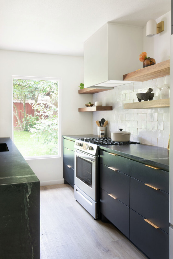 Exempel på ett mellanstort minimalistiskt svart svart kök, med en undermonterad diskho, släta luckor, svarta skåp, bänkskiva i täljsten, vitt stänkskydd, stänkskydd i keramik, rostfria vitvaror, ljust trägolv, en köksö och beiget golv