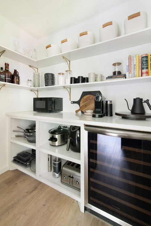 Bild på ett mellanstort nordiskt svart svart kök, med en undermonterad diskho, släta luckor, svarta skåp, bänkskiva i täljsten, vitt stänkskydd, stänkskydd i keramik, rostfria vitvaror, ljust trägolv, en köksö och beiget golv
