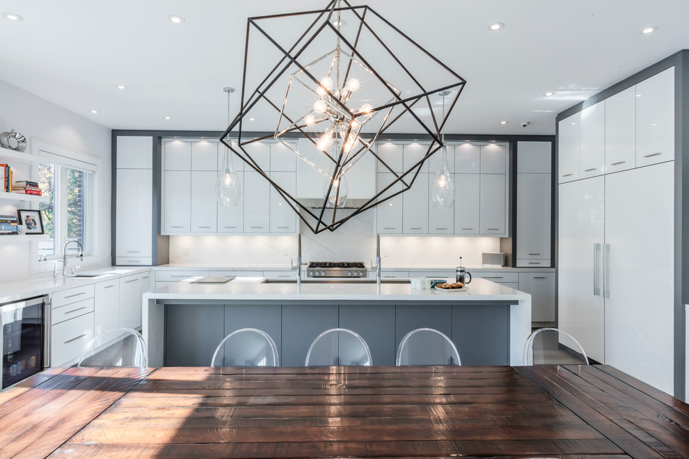 Inspiration for a large contemporary u-shaped dark wood floor eat-in kitchen remodel in Toronto with an undermount sink, flat-panel cabinets, white cabinets, marble countertops, white backsplash, stone slab backsplash, stainless steel appliances and an island