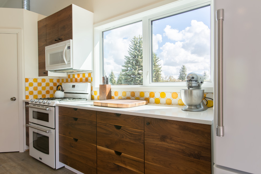 Kleine Moderne Wohnküche in L-Form mit Unterbauwaschbecken, flächenbündigen Schrankfronten, dunklen Holzschränken, Quarzit-Arbeitsplatte, Küchenrückwand in Gelb, weißen Elektrogeräten, Vinylboden und Kücheninsel in Edmonton