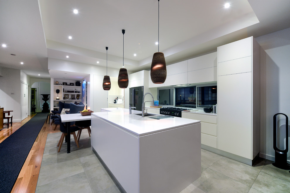 Inredning av ett modernt mellanstort linjärt kök med öppen planlösning, med en undermonterad diskho, släta luckor, vita skåp, granitbänkskiva, fönster som stänkskydd, svarta vitvaror, klinkergolv i keramik, en köksö och grått golv