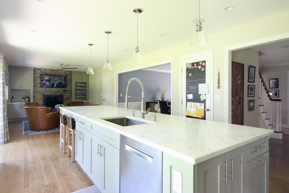 Bild på ett mellanstort vintage linjärt kök och matrum, med en undermonterad diskho, skåp i shakerstil, grå skåp, marmorbänkskiva, vitt stänkskydd, stänkskydd i tunnelbanekakel, rostfria vitvaror, mellanmörkt trägolv och en köksö