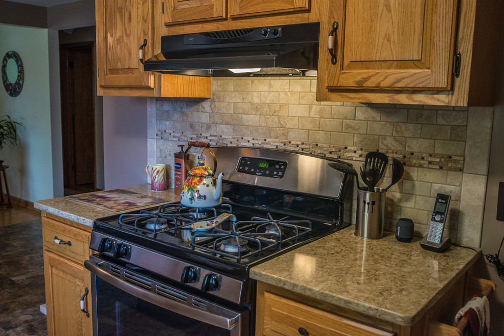 Cette photo montre une cuisine américaine parallèle nature de taille moyenne avec une crédence beige, une crédence en dalle de pierre, une péninsule et un sol marron.