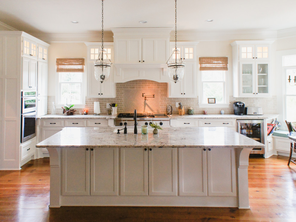 Inspiration for a large traditional l-shaped kitchen/diner in Atlanta with shaker cabinets, a submerged sink, white cabinets, granite worktops, beige splashback, metro tiled splashback, stainless steel appliances, medium hardwood flooring and an island.