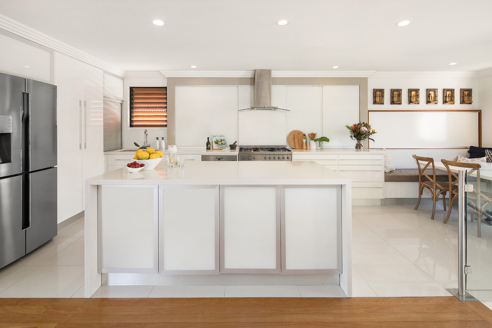 Idéer för att renovera ett funkis vit vitt kök, med släta luckor, vita skåp, rostfria vitvaror, en köksö och vitt golv