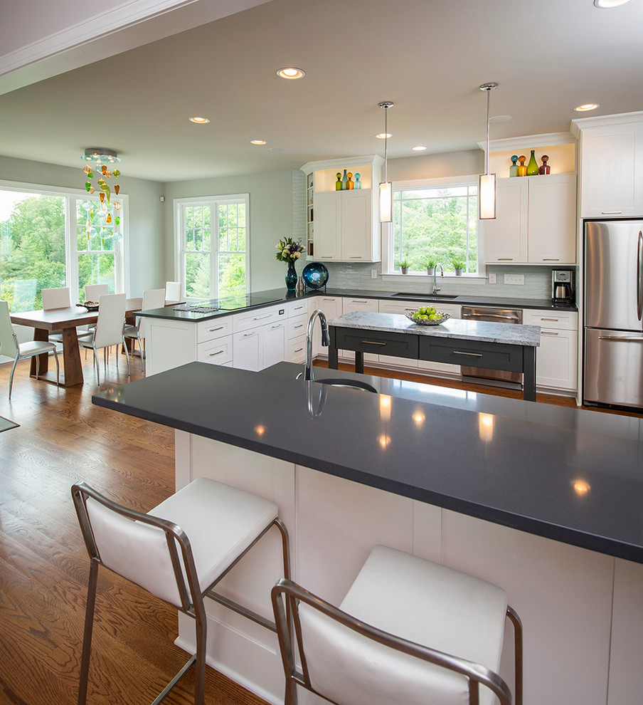 Inspiration for a large contemporary u-shaped medium tone wood floor eat-in kitchen remodel in Richmond with an undermount sink, shaker cabinets, white cabinets, quartzite countertops, white backsplash, glass sheet backsplash, stainless steel appliances and an island