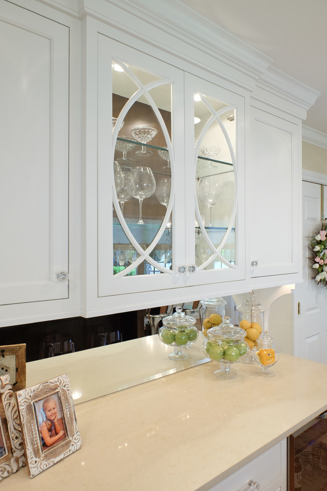 Eat-in kitchen - mid-sized traditional l-shaped medium tone wood floor eat-in kitchen idea in San Francisco with an undermount sink, flat-panel cabinets, white cabinets, quartz countertops, white backsplash, subway tile backsplash, stainless steel appliances and an island