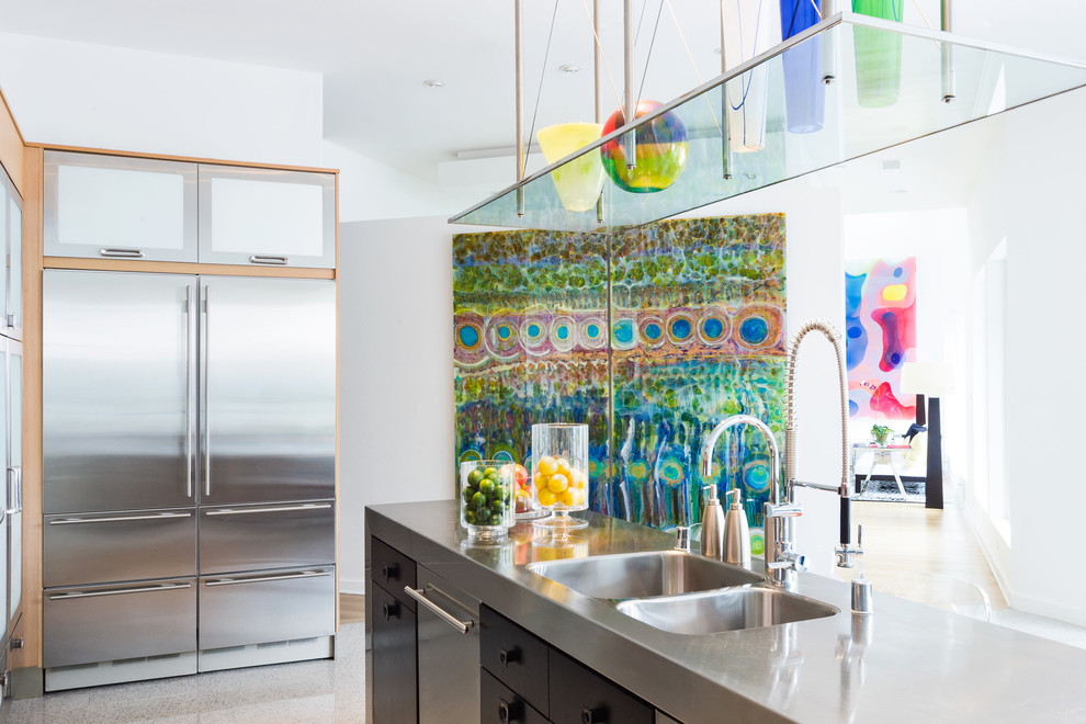 Large contemporary galley open plan kitchen in Dallas with a double-bowl sink, flat-panel cabinets, dark wood cabinets, stainless steel worktops, orange splashback, stainless steel appliances, terrazzo flooring, an island, white floors and grey worktops.