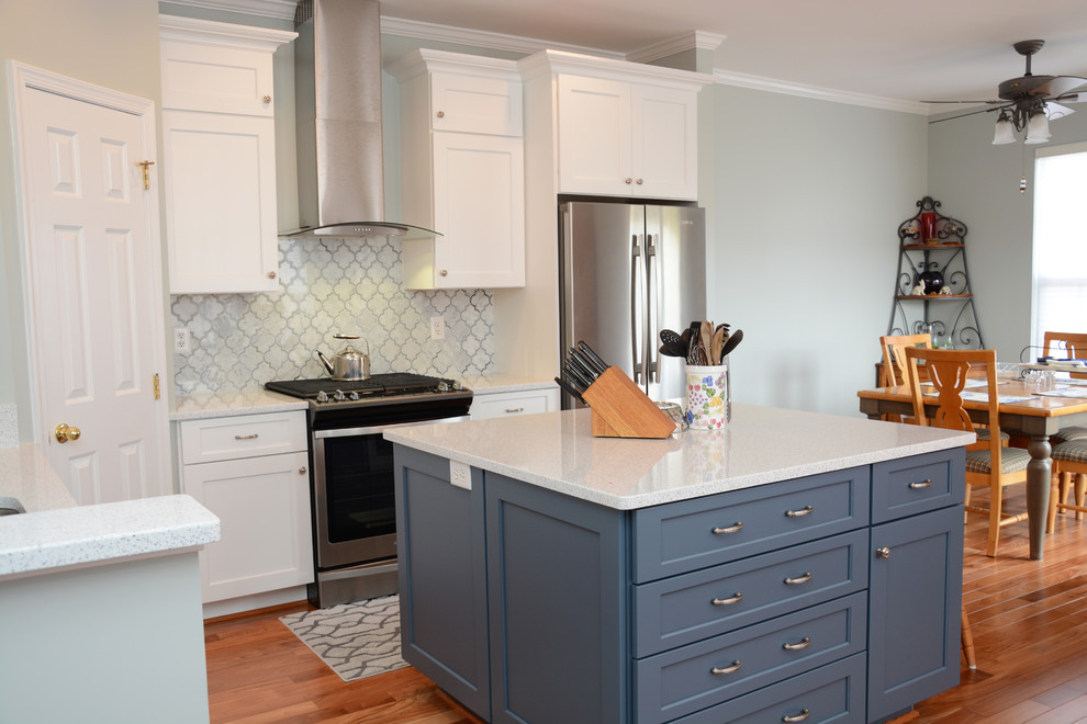 Photo of a medium sized traditional l-shaped kitchen/diner in Baltimore with a single-bowl sink, recessed-panel cabinets, white cabinets, engineered stone countertops, white splashback, stainless steel appliances, medium hardwood flooring, an island and brown floors.