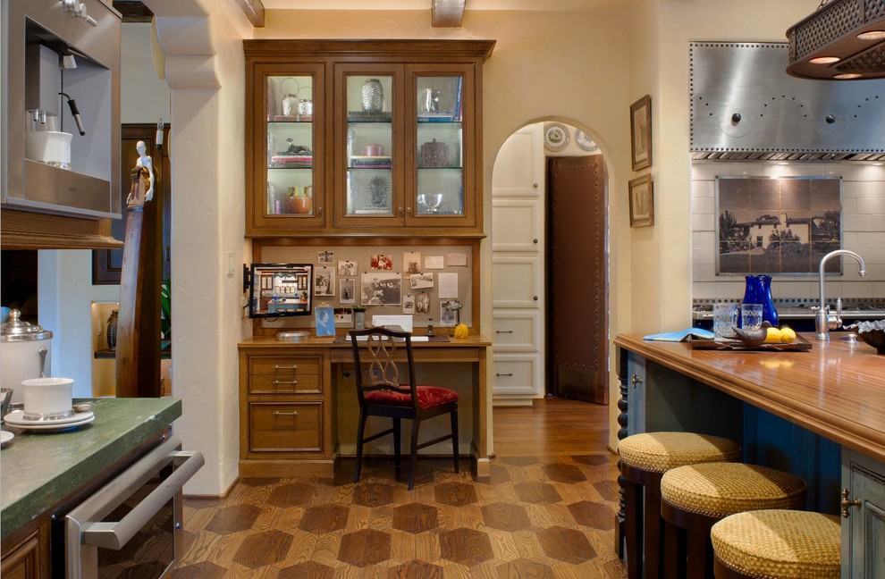 На фото: кухня в средиземноморском стиле с деревянной столешницей и зеленой столешницей