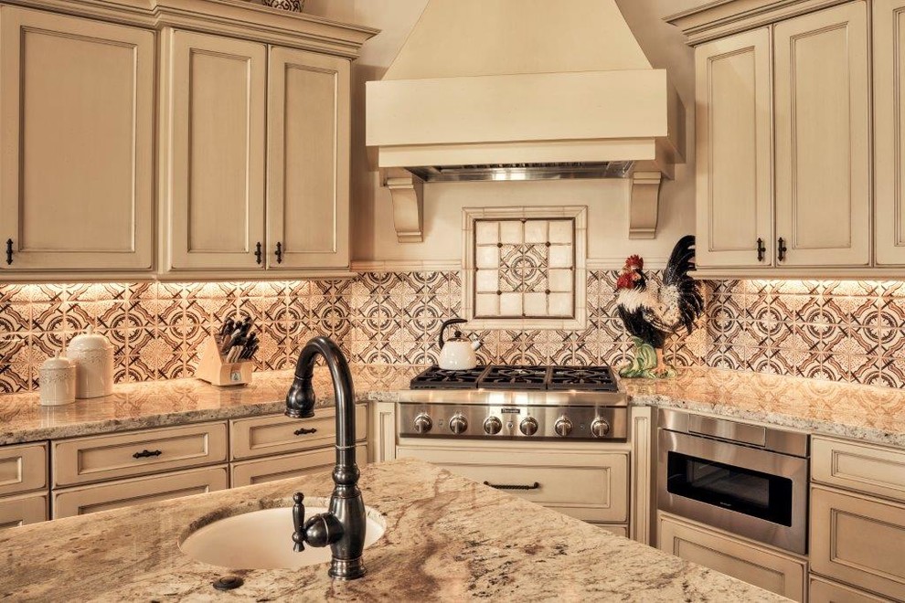 Inredning av ett medelhavsstil mellanstort kök, med en undermonterad diskho, luckor med infälld panel, beige skåp, granitbänkskiva, flerfärgad stänkskydd, stänkskydd i keramik, rostfria vitvaror och en köksö