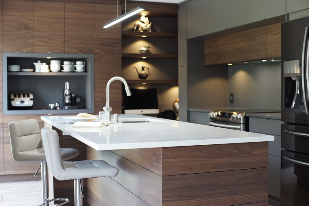 Immagine di una cucina minimalista chiusa e di medie dimensioni con lavello sottopiano, ante lisce, ante in legno bruno, top in superficie solida, elettrodomestici in acciaio inossidabile, parquet scuro e pavimento marrone