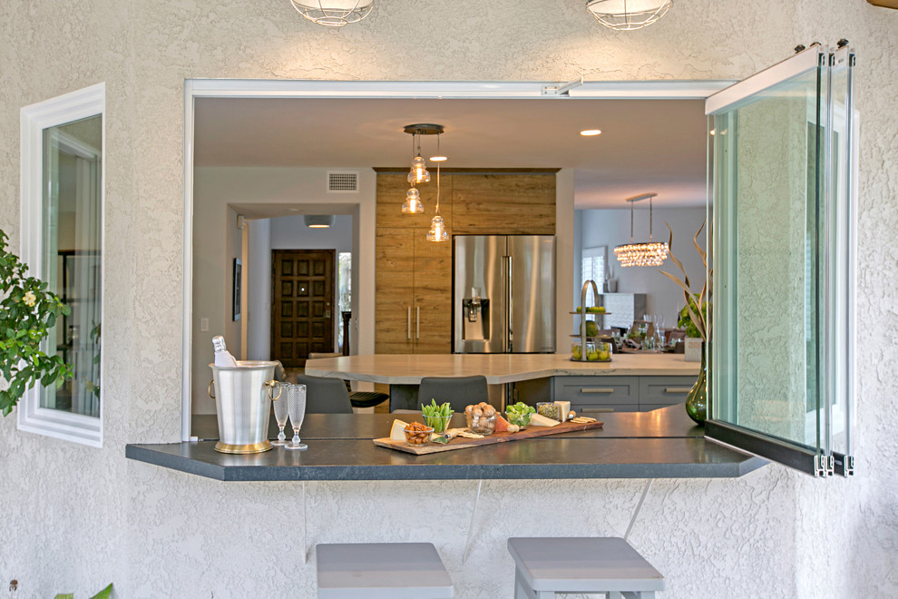 Example of a large transitional u-shaped medium tone wood floor and brown floor eat-in kitchen design in San Diego with an undermount sink, shaker cabinets, gray cabinets, quartzite countertops, white backsplash, subway tile backsplash, stainless steel appliances and an island