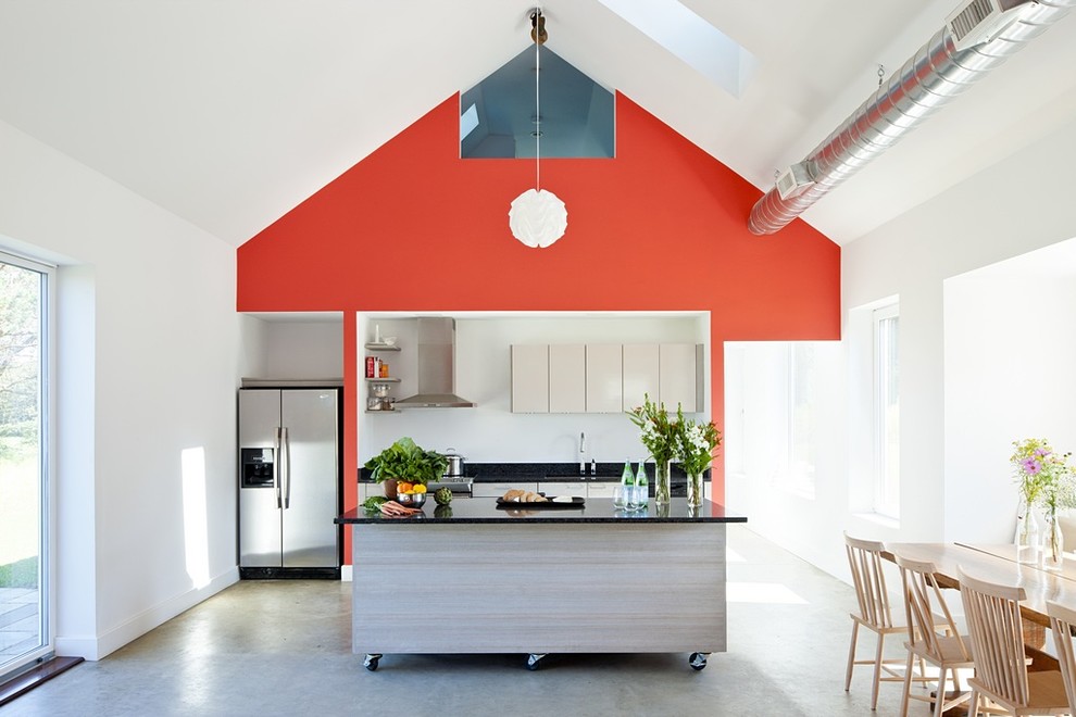 Cottage single-wall concrete floor and gray floor eat-in kitchen photo in Providence with an undermount sink, flat-panel cabinets, light wood cabinets, stainless steel appliances and an island