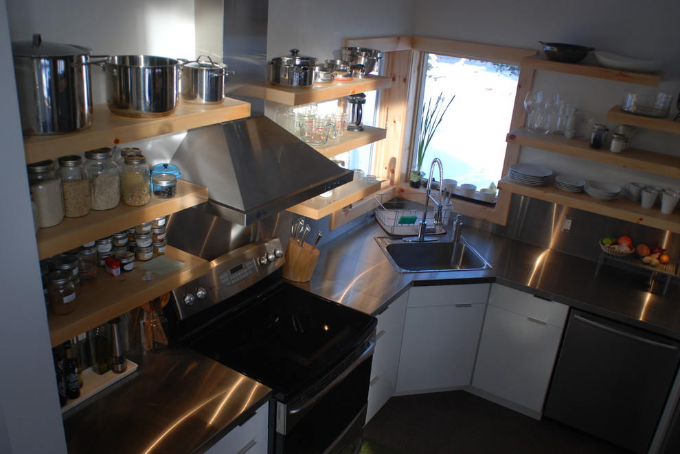 Immagine di una cucina moderna con ante lisce, ante bianche, top in acciaio inossidabile, elettrodomestici in acciaio inossidabile, pavimento in cemento, nessuna isola e pavimento grigio