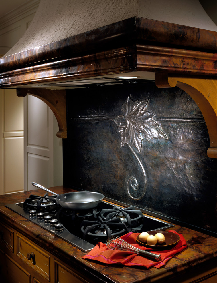 Imagen de cocina bohemia pequeña con armarios con paneles lisos, puertas de armario de madera oscura, salpicadero negro y electrodomésticos de acero inoxidable