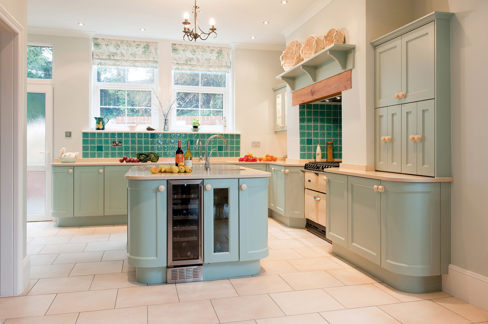 Foto på ett lantligt kök, med luckor med infälld panel, blå skåp, blått stänkskydd, stänkskydd i keramik, vita vitvaror och en köksö