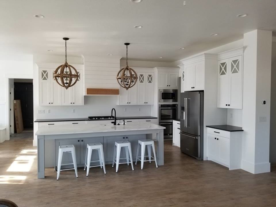 Exempel på ett mellanstort lantligt grå linjärt grått kök, med en undermonterad diskho, skåp i shakerstil, vita skåp, granitbänkskiva, rostfria vitvaror, mellanmörkt trägolv, en köksö och brunt golv
