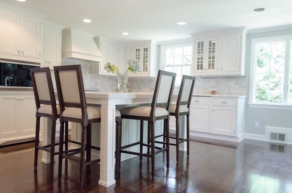 Exempel på ett mellanstort klassiskt kök, med luckor med infälld panel, vita skåp, marmorbänkskiva, grått stänkskydd, stänkskydd i stenkakel, rostfria vitvaror, mörkt trägolv, en köksö och brunt golv