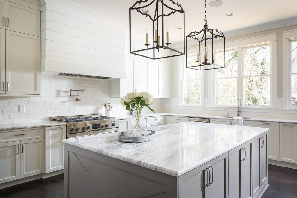 This is an example of a nautical grey and white kitchen in Other with a submerged sink, shaker cabinets, white cabinets, window splashback, stainless steel appliances, dark hardwood flooring, an island and brown floors.