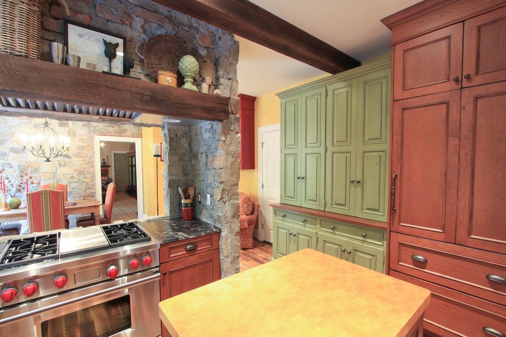 Cette photo montre une cuisine montagne avec un électroménager en acier inoxydable et un plan de travail en bois.