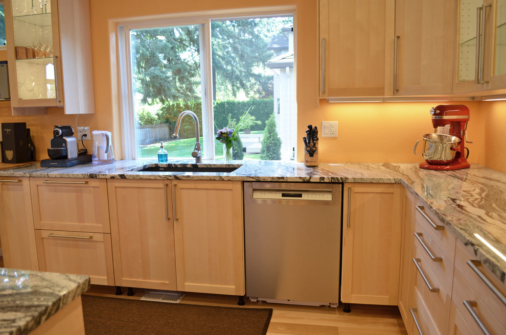 Exempel på ett stort modernt kök, med en enkel diskho, skåp i shakerstil, skåp i ljust trä, granitbänkskiva, rostfria vitvaror, mellanmörkt trägolv, en köksö och beiget golv