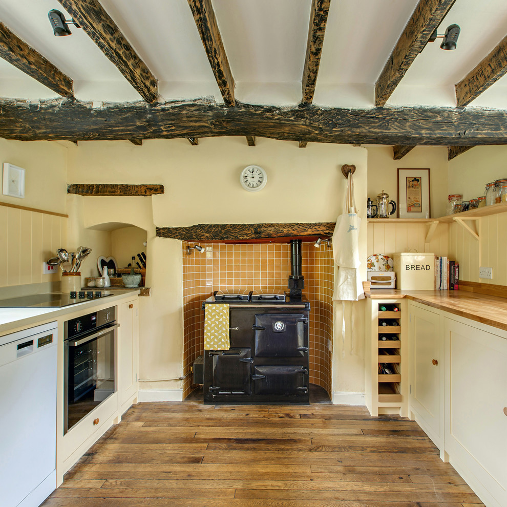 Design ideas for a rural galley kitchen in Other with shaker cabinets, yellow cabinets, wood worktops, orange splashback, black appliances, medium hardwood flooring and no island.