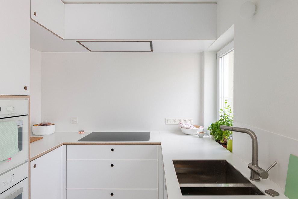 Scandi u-shaped kitchen in Brussels with a double-bowl sink, flat-panel cabinets, white cabinets, white appliances and no island.