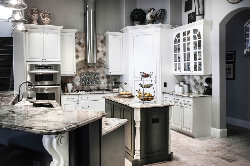 This is an example of a large classic u-shaped kitchen/diner in Orlando with white cabinets, multiple islands, a submerged sink, raised-panel cabinets, marble worktops, grey splashback, ceramic splashback, stainless steel appliances and porcelain flooring.