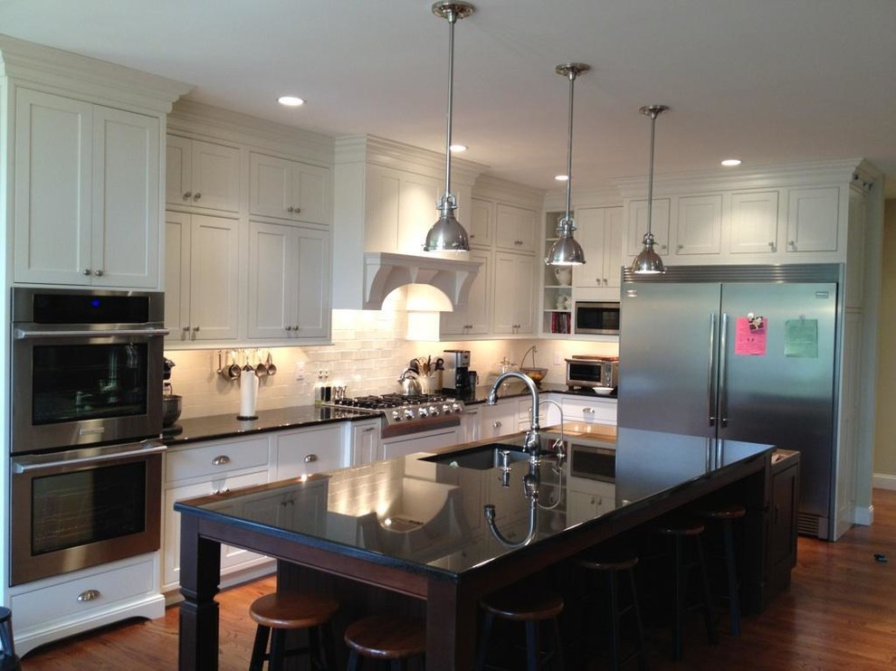 Example of a classic l-shaped eat-in kitchen design in Philadelphia with a single-bowl sink, beaded inset cabinets, white cabinets, granite countertops, beige backsplash, stone tile backsplash and stainless steel appliances