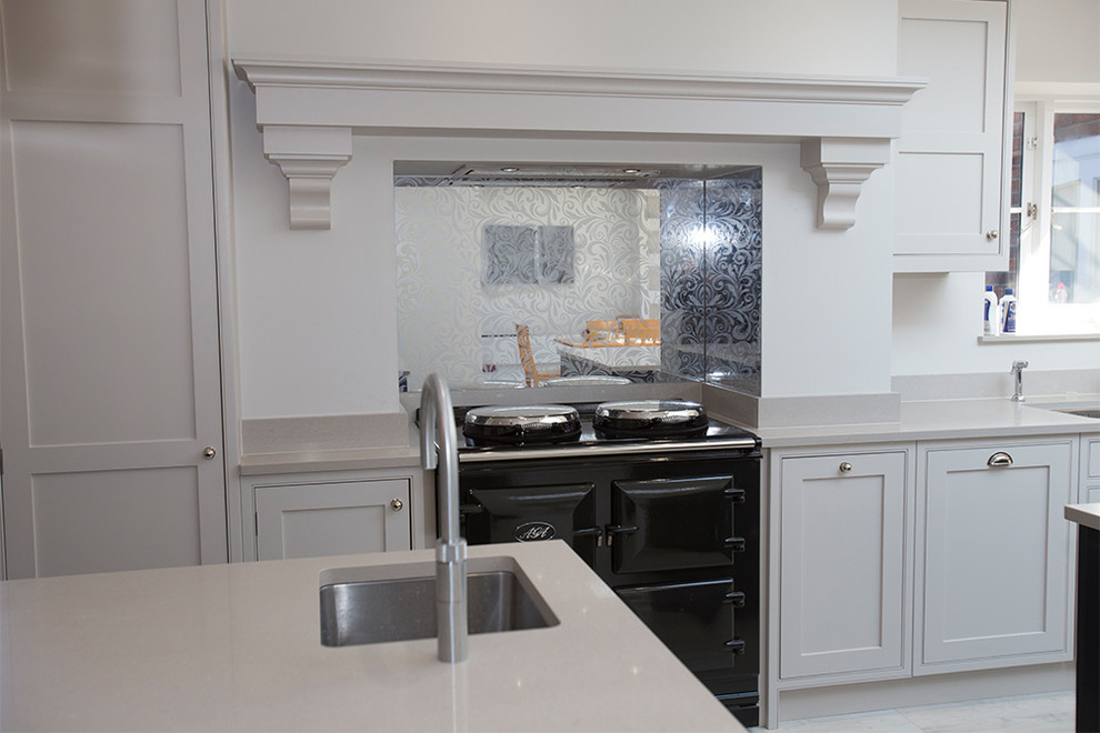 Imagen de cocina comedor minimalista grande con puertas de armario blancas, salpicadero multicolor, salpicadero de vidrio templado, una isla y encimeras blancas