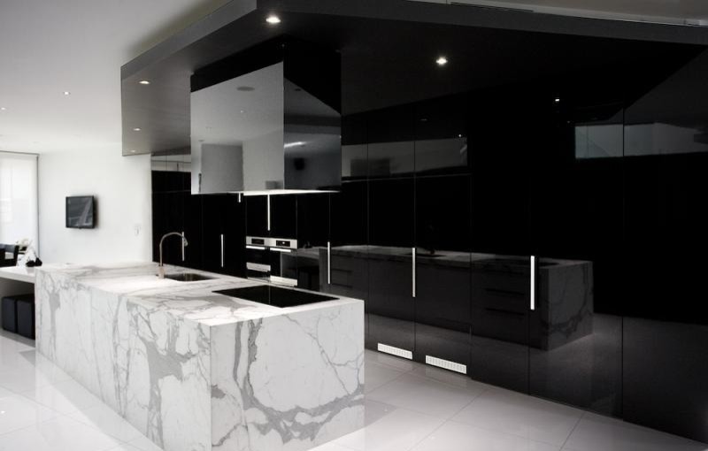 Foto på ett funkis kök och matrum, med en undermonterad diskho, luckor med lamellpanel, svarta skåp, marmorbänkskiva och rostfria vitvaror
