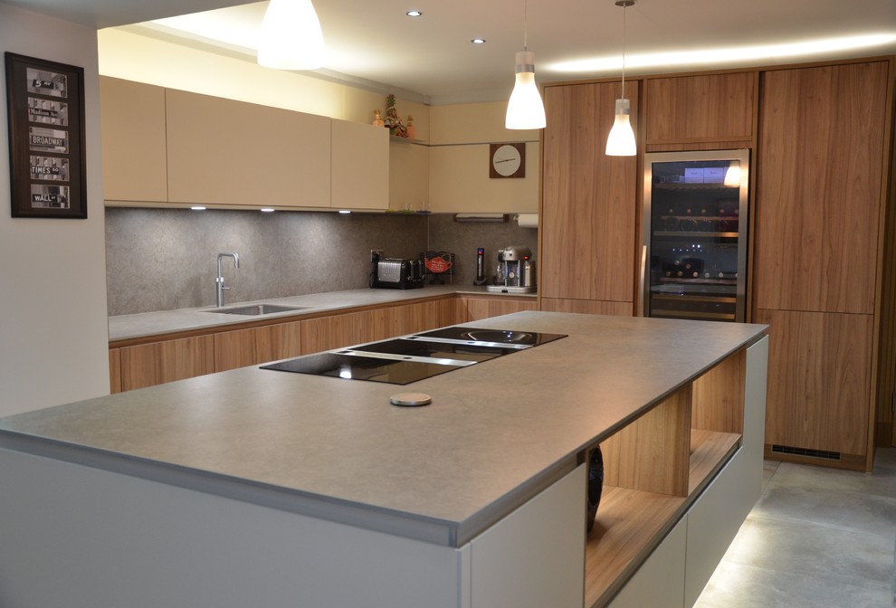 Modern inredning av ett mellanstort kök, med en integrerad diskho, integrerade vitvaror, en köksö, luckor med profilerade fronter, skåp i mellenmörkt trä, träbänkskiva, brunt stänkskydd, stänkskydd i marmor, klinkergolv i keramik och grått golv