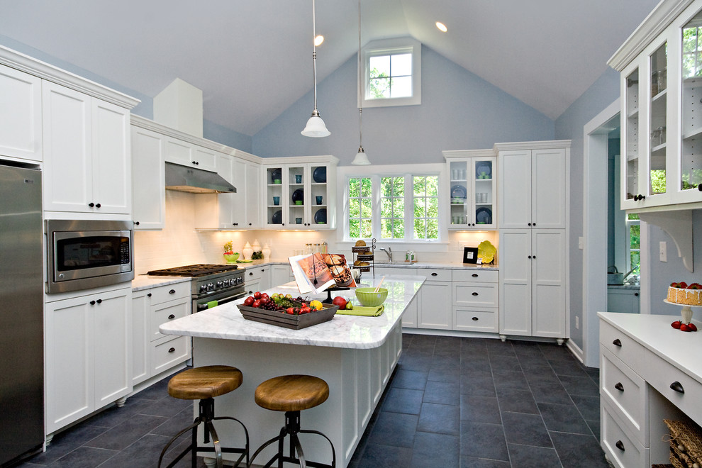 Kitchen - mid-sized farmhouse l-shaped porcelain tile and gray floor kitchen idea in Raleigh with an undermount sink, shaker cabinets, white cabinets, quartzite countertops, white backsplash, stainless steel appliances and an island