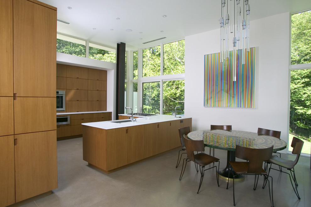 На фото: п-образная кухня в стиле модернизм с обеденным столом, плоскими фасадами и фасадами цвета дерева среднего тона