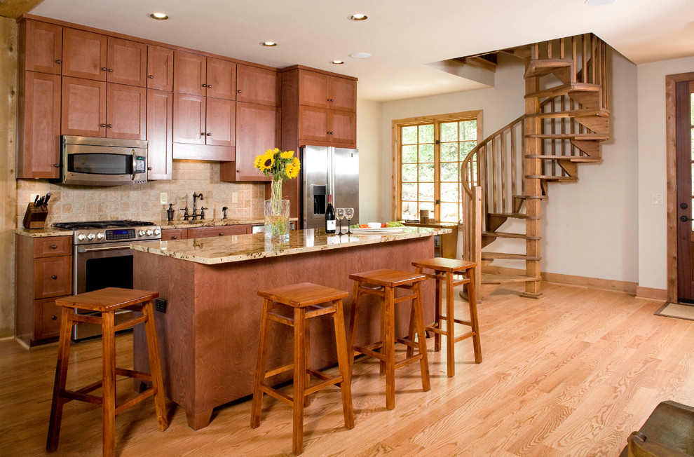 Idéer för ett mellanstort amerikanskt kök, med luckor med infälld panel, skåp i mellenmörkt trä, granitbänkskiva, beige stänkskydd, stänkskydd i stenkakel, rostfria vitvaror, ljust trägolv, en köksö, en nedsänkt diskho och brunt golv