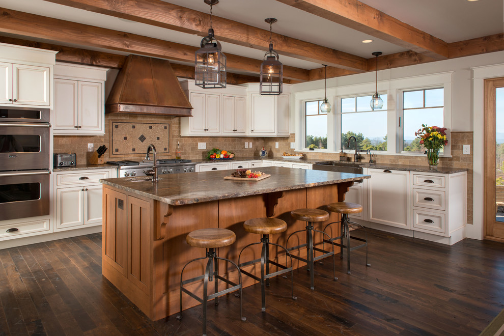 Large rustic l-shaped open plan kitchen in Burlington with a belfast sink, recessed-panel cabinets, white cabinets, brown splashback, stainless steel appliances, medium hardwood flooring, an island and brown floors.