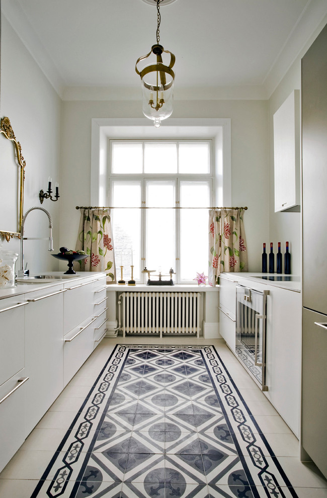 Photo of a classic galley kitchen in London with a submerged sink and white cabinets.